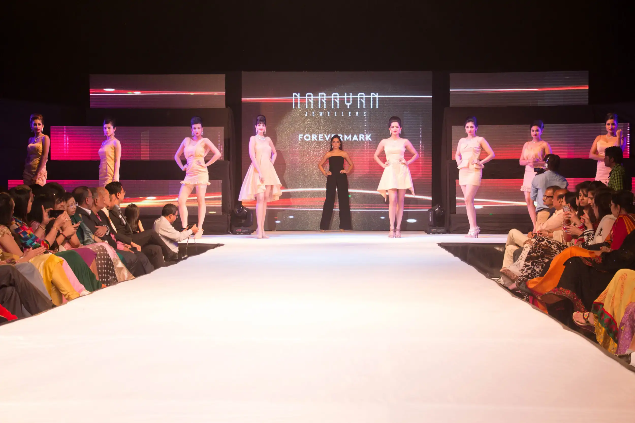 Balloon arch in orange, black, and white colors framing an ITT logo board lit with warm lights